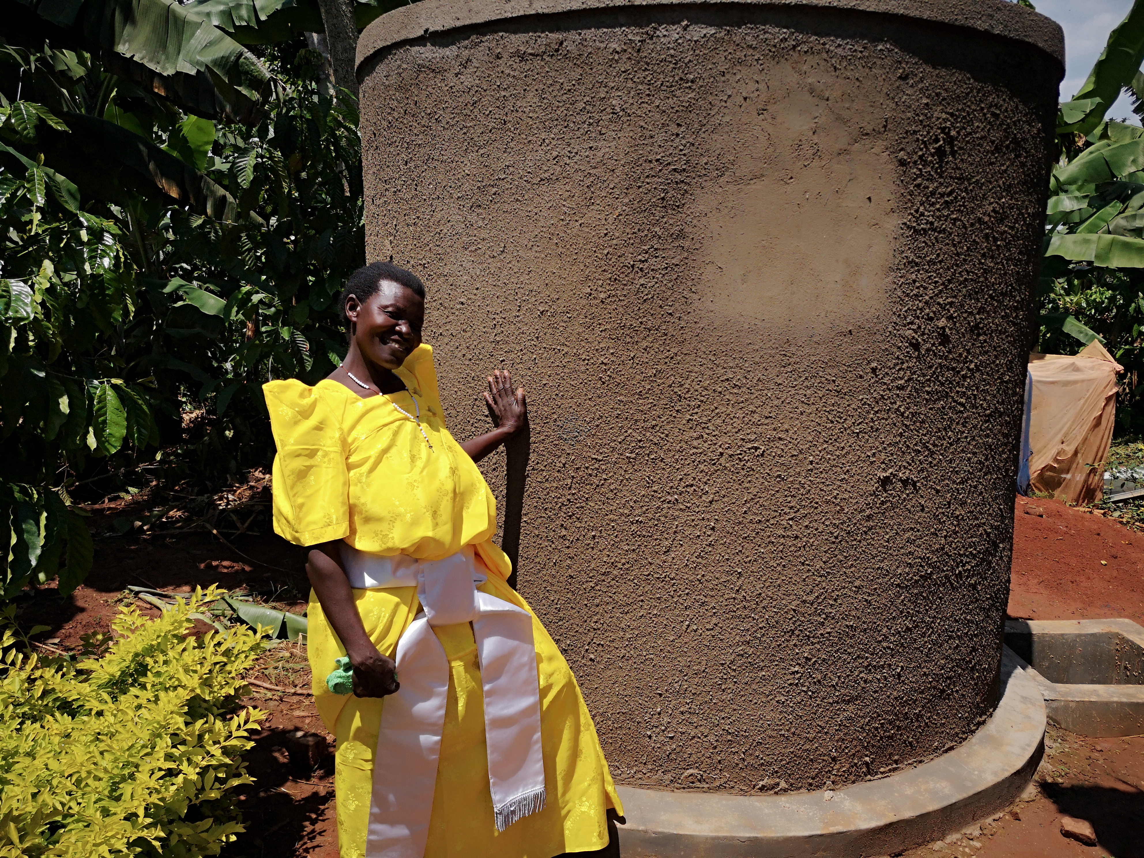 Frau im gelben Kleid vor Wassertank
