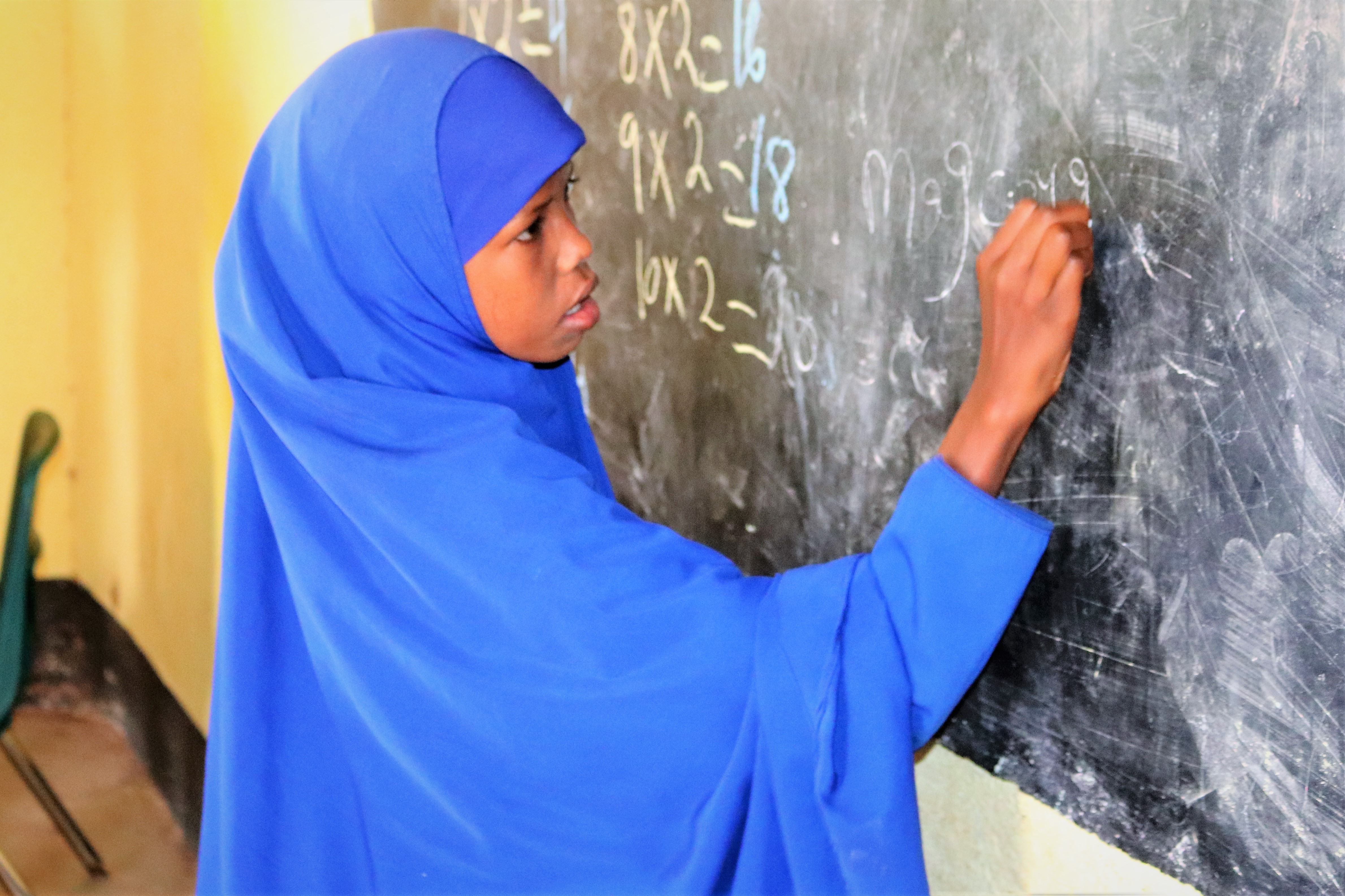 Schülerin aus Somalia schreibt an Tafel